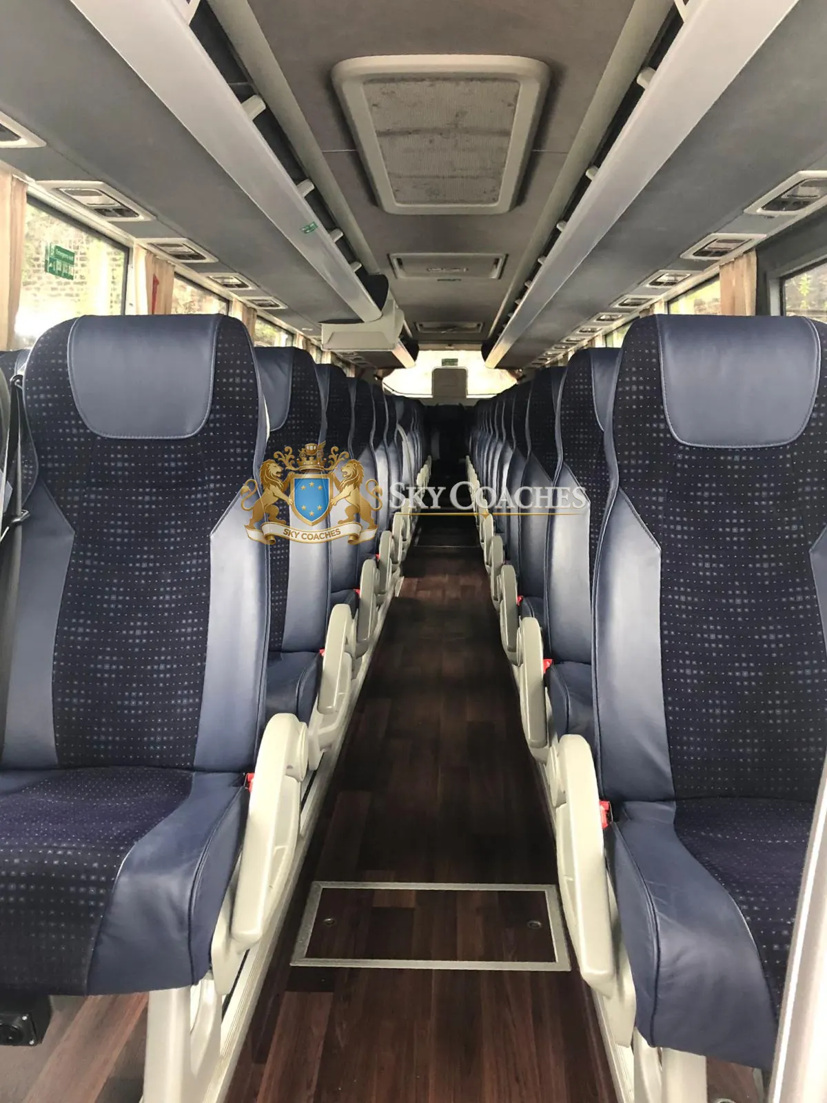 Touring coach interior with upholstered seats and a central aisle