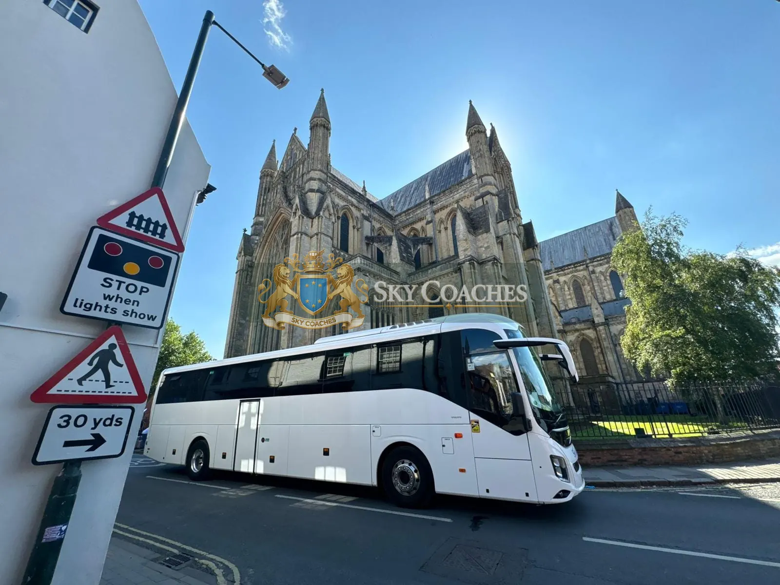 Sky Coaches white Volvo coach beside a cathedral